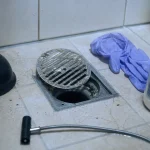 Déboucher douche produit : furet et déboucheur près d’une bonde de douche encombrée de cheveux
